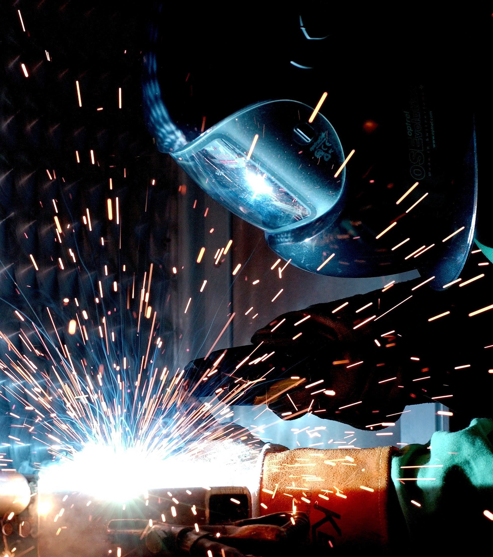 Image of a worker TIG welding a piece of metal.